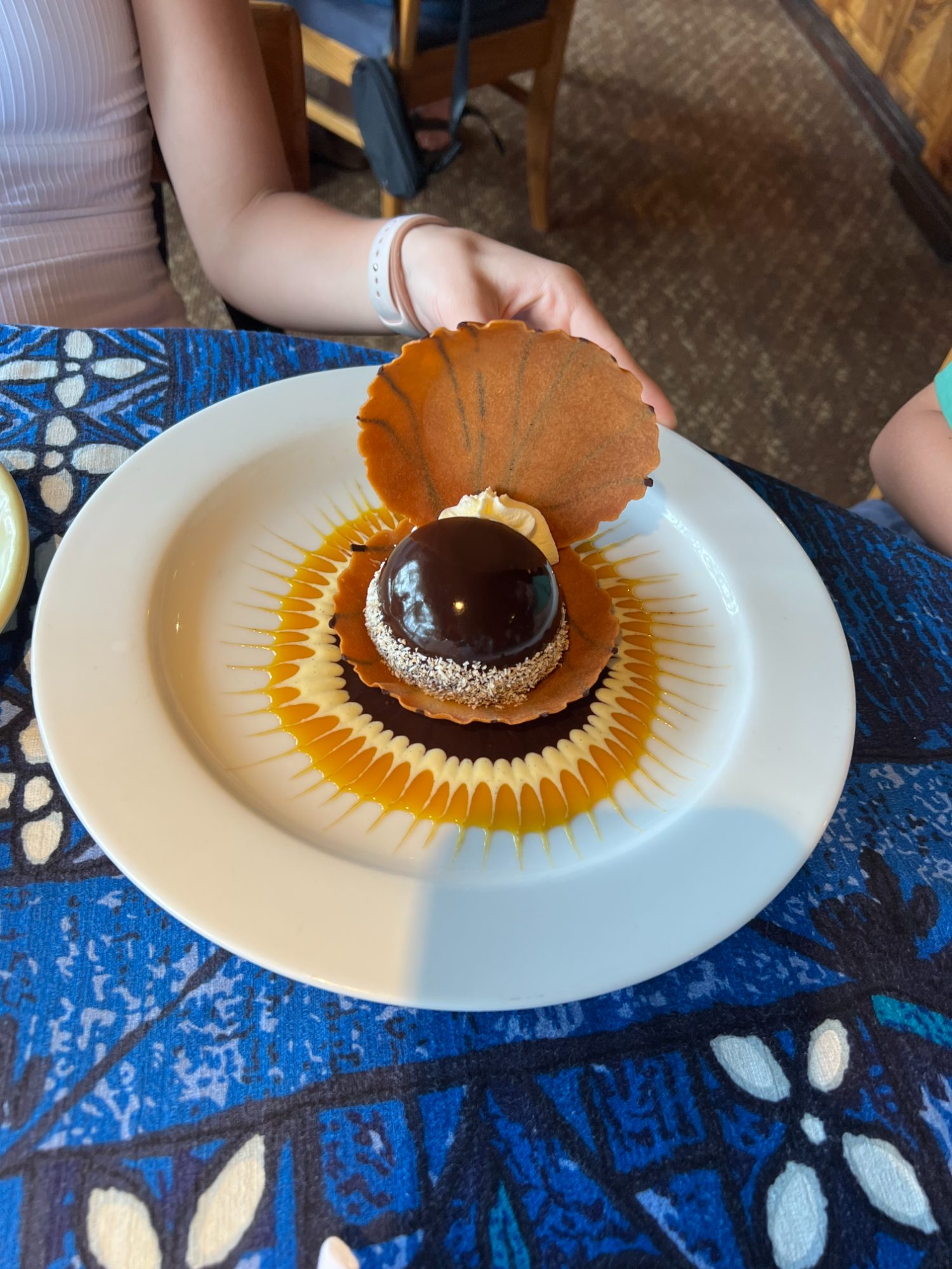 A chocolate-dome dessert plated on a shell-shaped tuile at Mama's Fish House